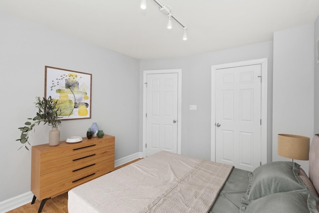 bedroom featuring light wood-type flooring and rail lighting