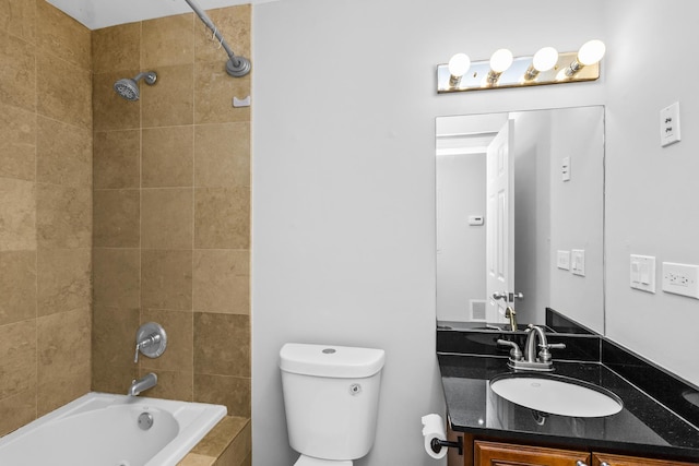 full bathroom featuring toilet, tiled shower / bath, and vanity