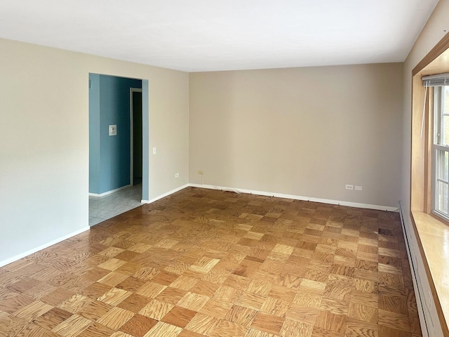 empty room with a baseboard heating unit and light parquet floors