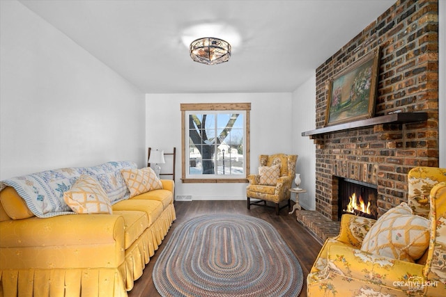 living room featuring dark wood-type flooring and a fireplace