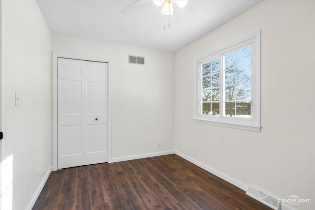 unfurnished bedroom with ceiling fan, a closet, and dark hardwood / wood-style flooring