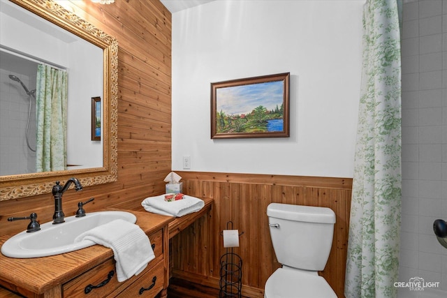 bathroom featuring sink, toilet, a shower with curtain, and wooden walls