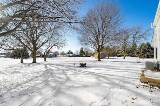 yard layered in snow with central AC and a storage unit