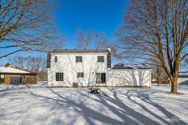 snow covered rear of property with central AC unit