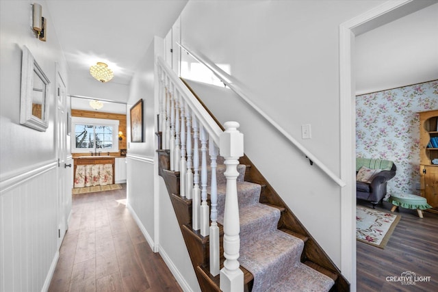 stairs featuring wood-type flooring and sink