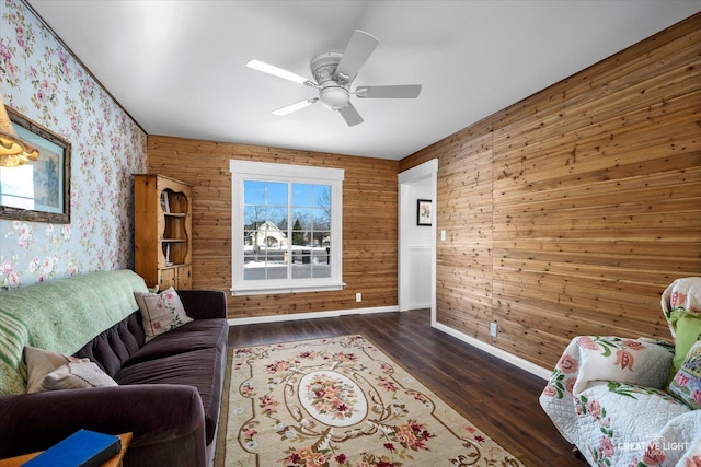 living room featuring ceiling fan, dark wood-type flooring, and wooden walls