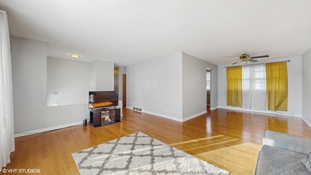 living room featuring ceiling fan and hardwood / wood-style floors