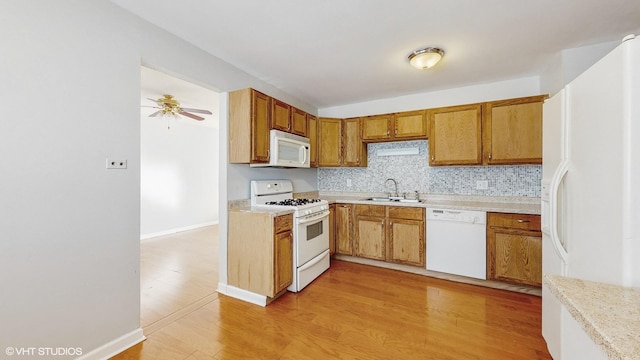 kitchen with ceiling fan, decorative backsplash, sink, white appliances, and light wood-type flooring