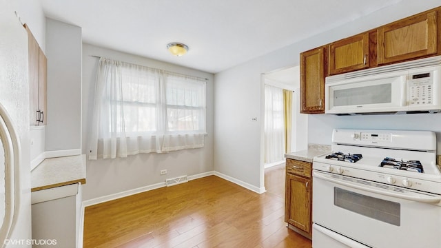 kitchen with light wood-type flooring and white appliances