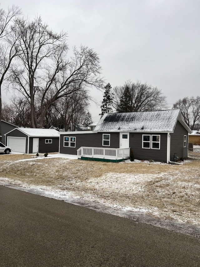 view of front of home with a garage and an outbuilding