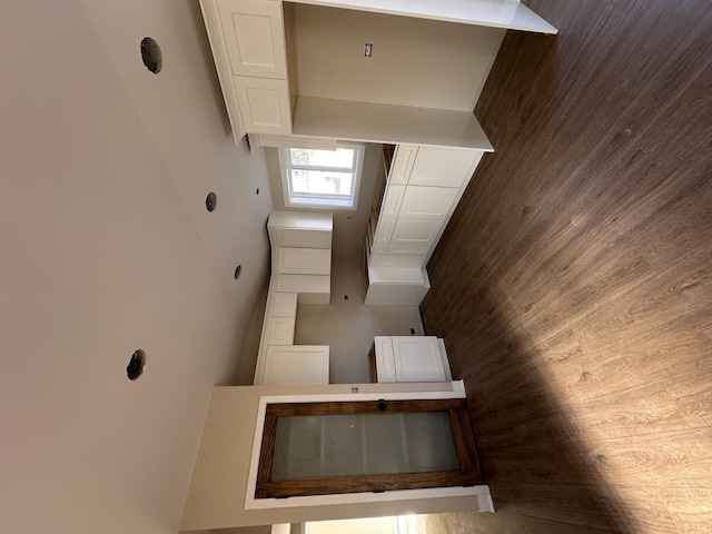 kitchen featuring white cabinetry and wood walls