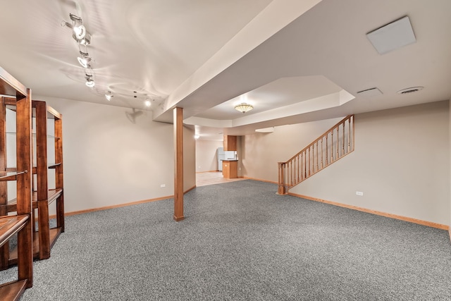 basement featuring track lighting and carpet