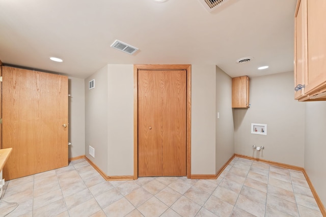 laundry room with washer hookup, cabinets, and light tile patterned flooring