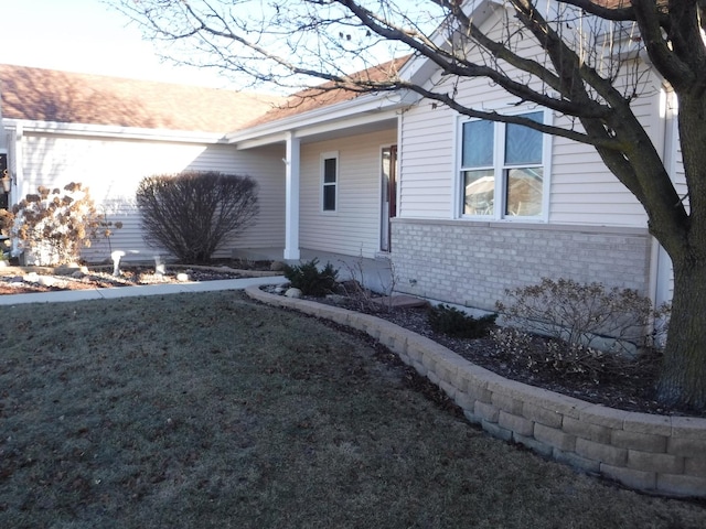 view of side of home with a yard