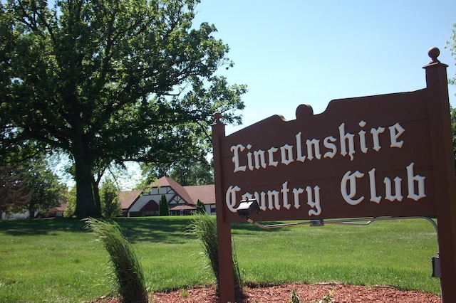 community / neighborhood sign featuring a yard