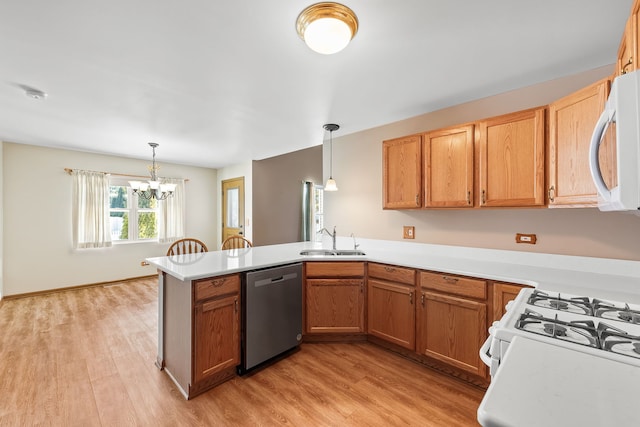 kitchen with dishwasher, sink, hanging light fixtures, kitchen peninsula, and light wood-type flooring