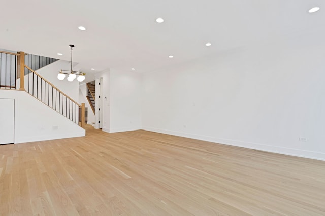 unfurnished living room featuring light hardwood / wood-style flooring and a notable chandelier