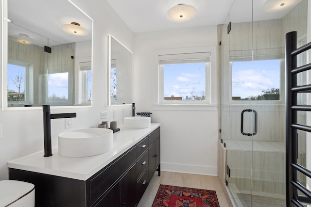 bathroom with walk in shower, vanity, and hardwood / wood-style floors