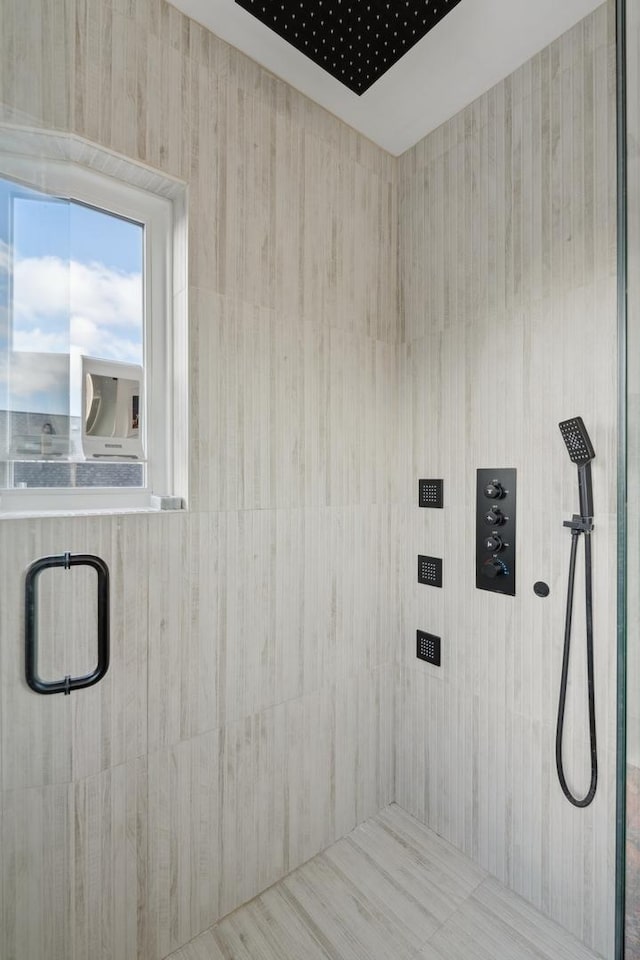 bathroom featuring tiled shower and elevator