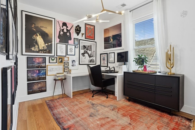 home office with hardwood / wood-style floors and a notable chandelier