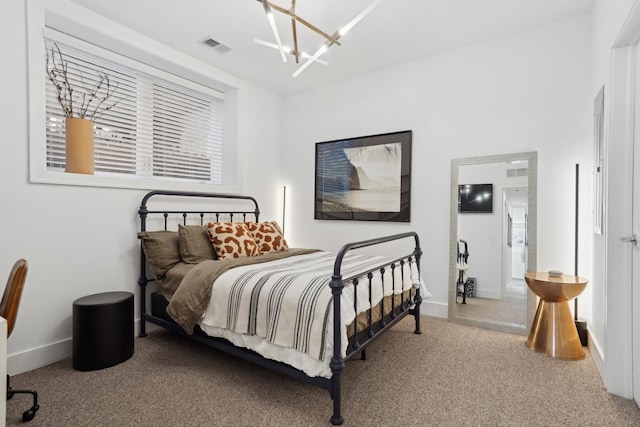 carpeted bedroom with an inviting chandelier