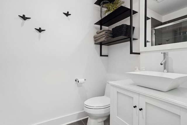 bathroom featuring toilet, vanity, an enclosed shower, and tile patterned floors