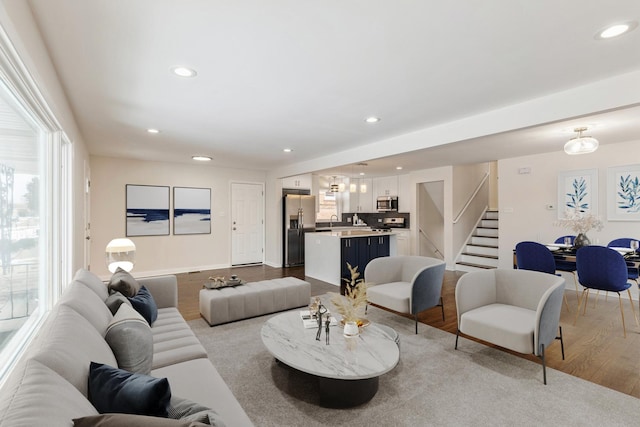 living room featuring sink, light hardwood / wood-style flooring, and a healthy amount of sunlight