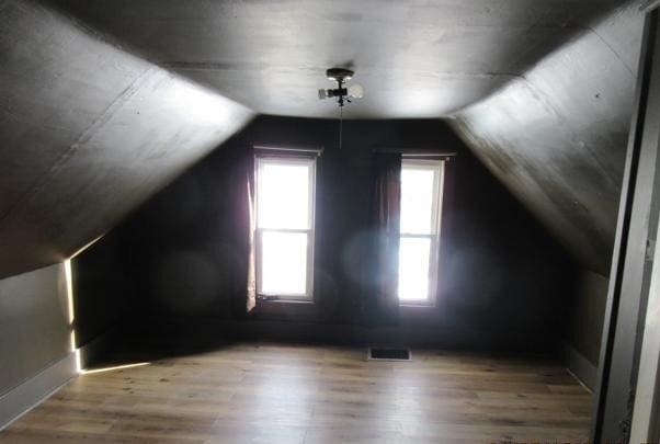 bonus room with lofted ceiling and hardwood / wood-style floors