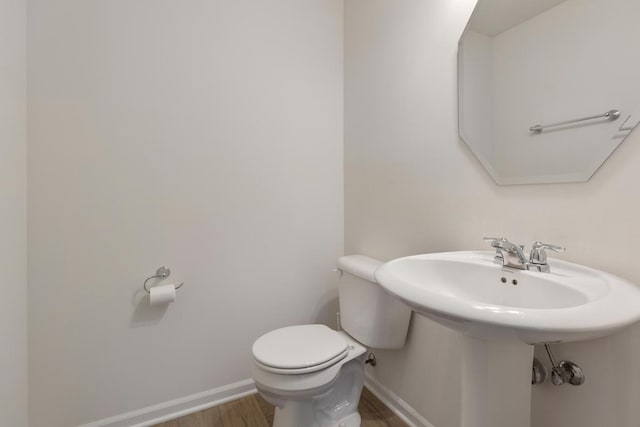 bathroom with hardwood / wood-style floors and toilet