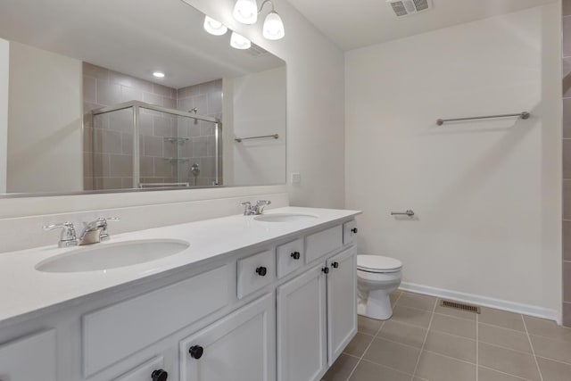 bathroom featuring tile patterned flooring, vanity, an enclosed shower, and toilet