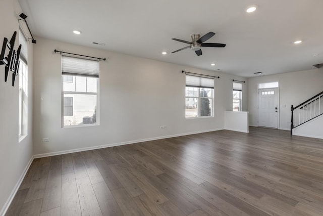 unfurnished living room with dark hardwood / wood-style flooring, plenty of natural light, and ceiling fan