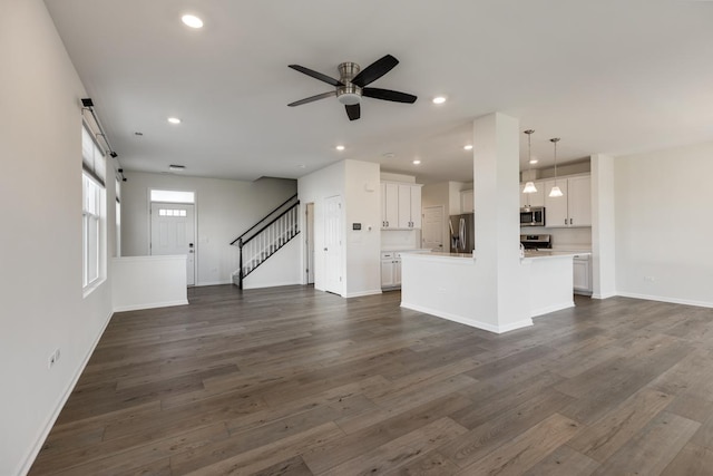 unfurnished living room with ceiling fan and dark hardwood / wood-style floors