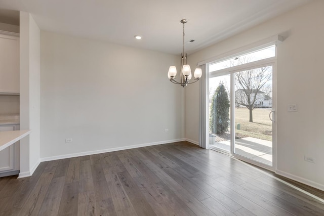 unfurnished dining area with dark hardwood / wood-style flooring and a chandelier