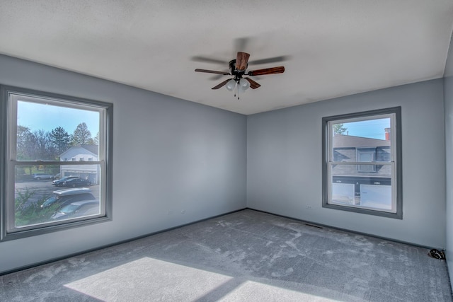 empty room with ceiling fan and carpet flooring