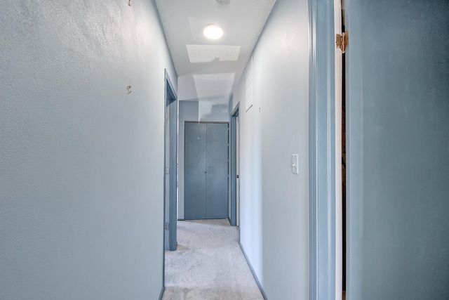 hallway featuring light colored carpet