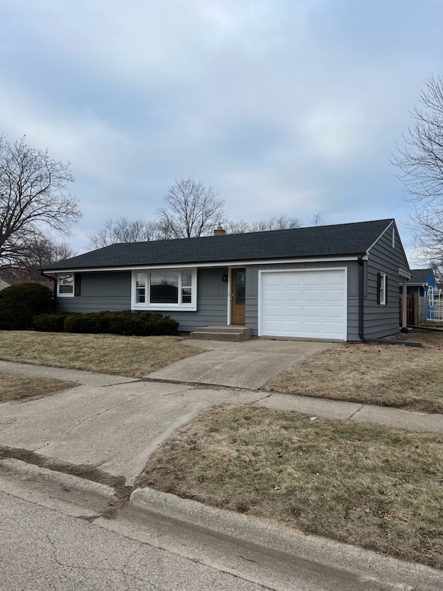 single story home with a garage and a front lawn