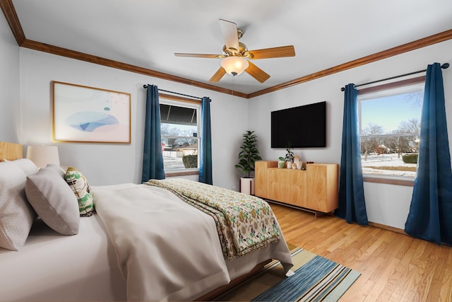 bedroom with ceiling fan, crown molding, light hardwood / wood-style flooring, and multiple windows