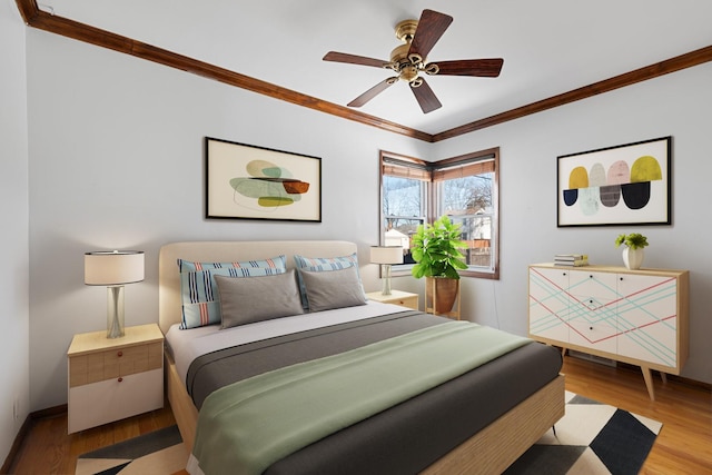 bedroom with ceiling fan, crown molding, and light hardwood / wood-style flooring