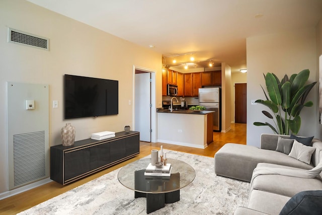 living room featuring sink and light hardwood / wood-style floors