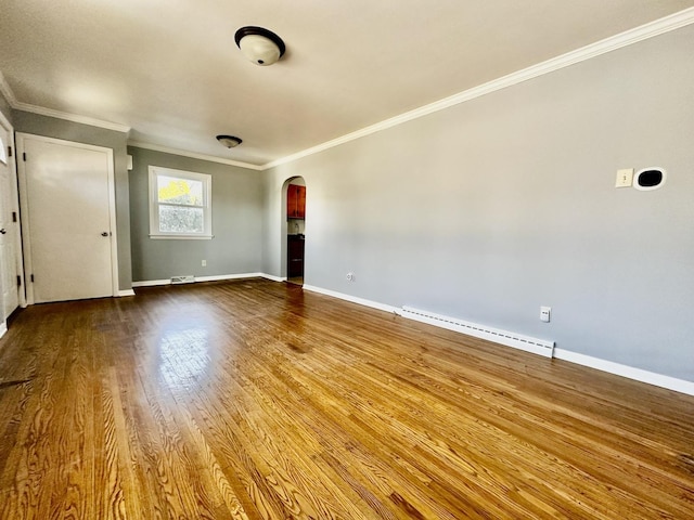 empty room with wood-type flooring, a baseboard heating unit, and ornamental molding