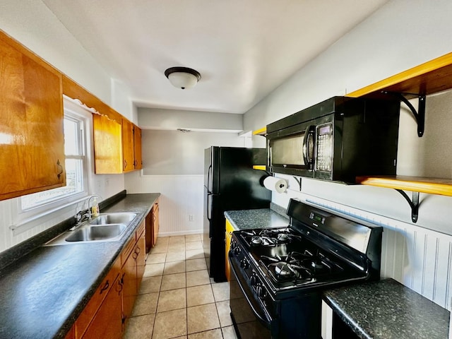 kitchen with black appliances, light tile patterned floors, and sink