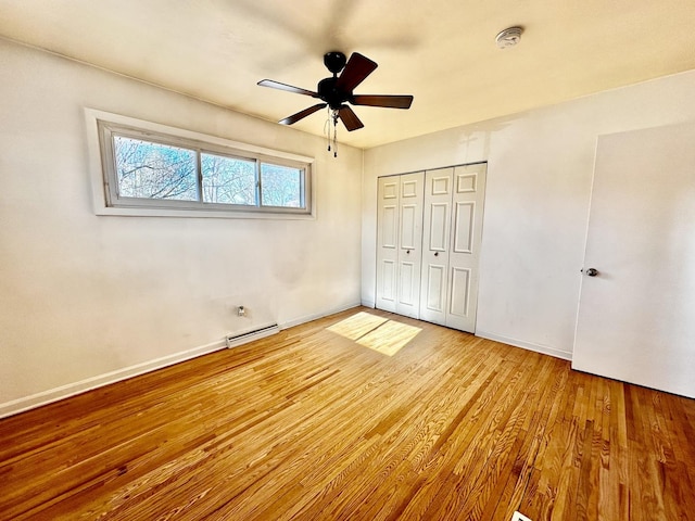 unfurnished bedroom featuring light wood-type flooring, ceiling fan, a closet, and a baseboard radiator