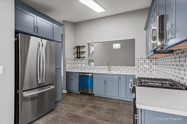 kitchen featuring sink, blue cabinetry, hanging light fixtures, stainless steel appliances, and tasteful backsplash