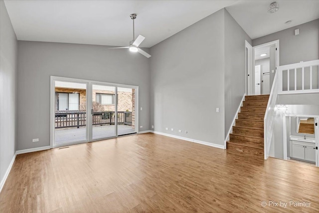 unfurnished living room with ceiling fan, high vaulted ceiling, and light wood-type flooring