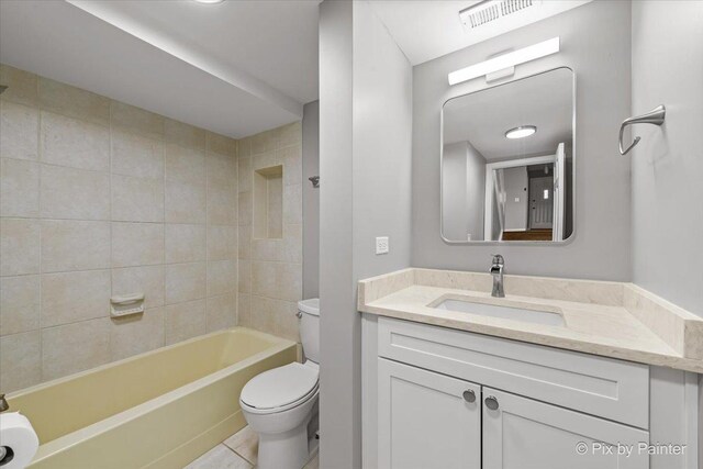 full bathroom with tiled shower / bath combo, vanity, and toilet