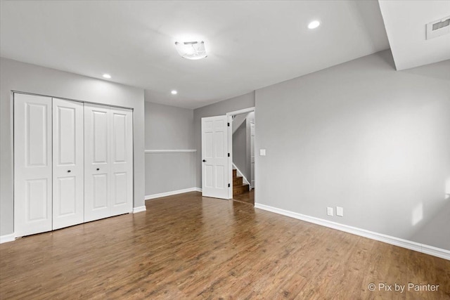 unfurnished bedroom featuring dark hardwood / wood-style floors and a closet