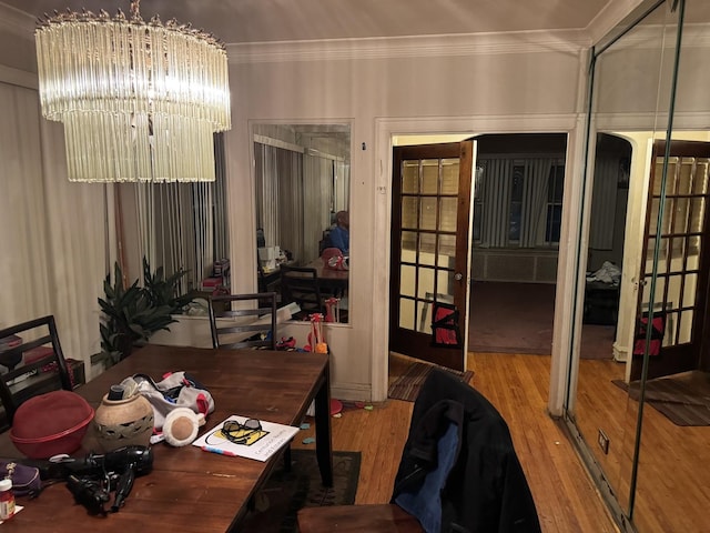 interior space with a chandelier, crown molding, and wood-type flooring