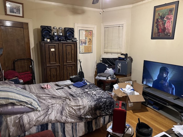 bedroom with ceiling fan, ornamental molding, and hardwood / wood-style flooring