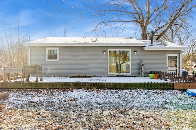 snow covered rear of property featuring a deck