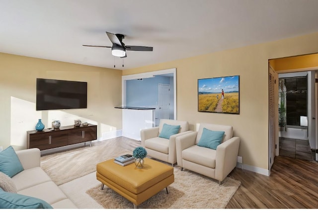 living room with ceiling fan and light wood-type flooring